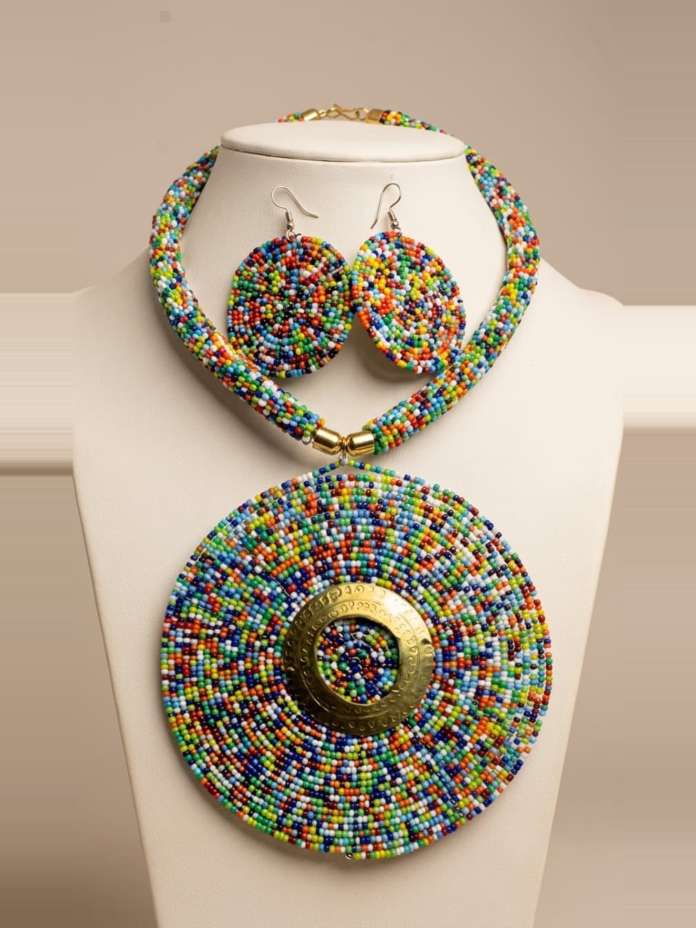 Multicolour beaded disc necklace and earrings on a display bust